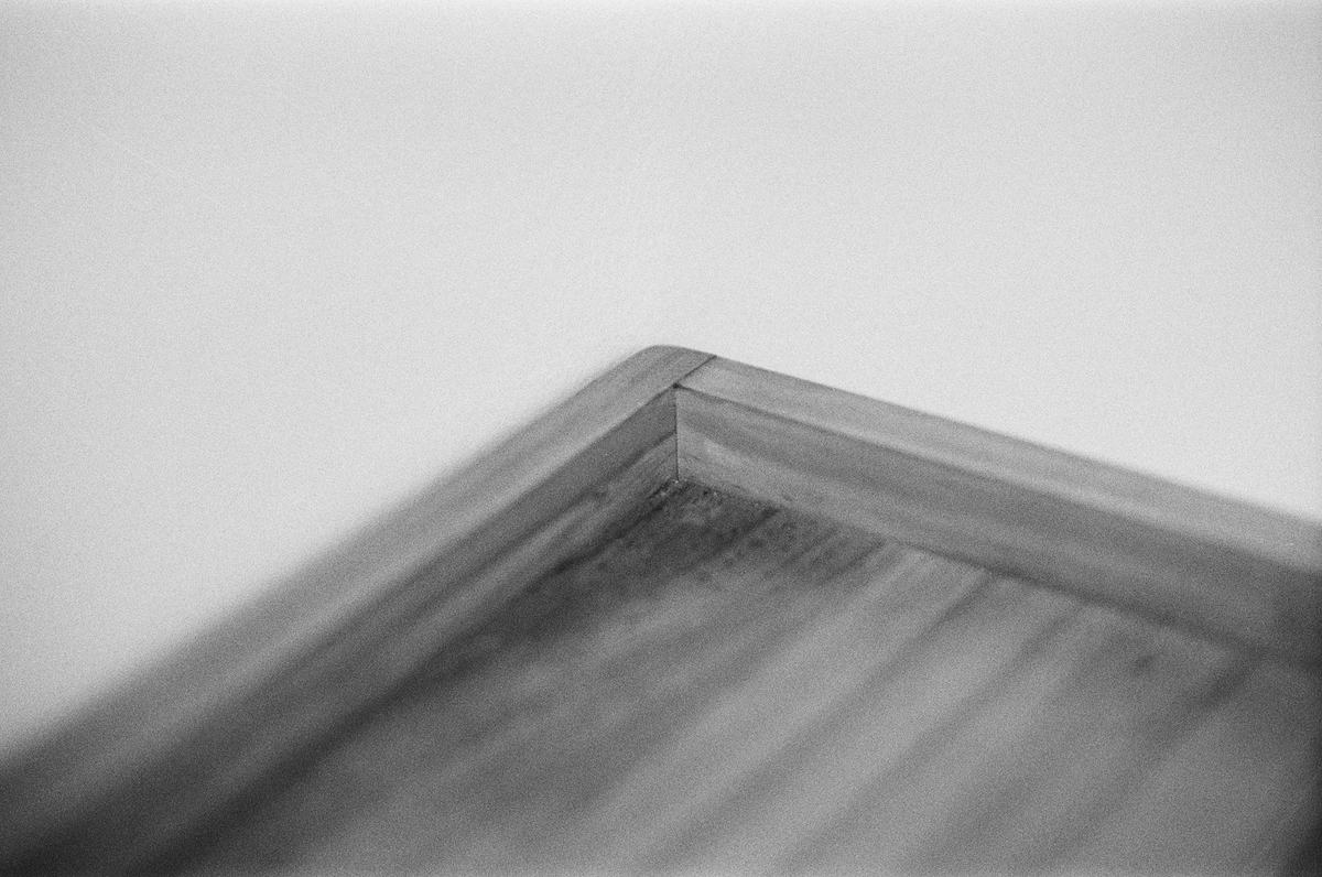 Black-and-white close view of a mitered outside corner in wood trim.