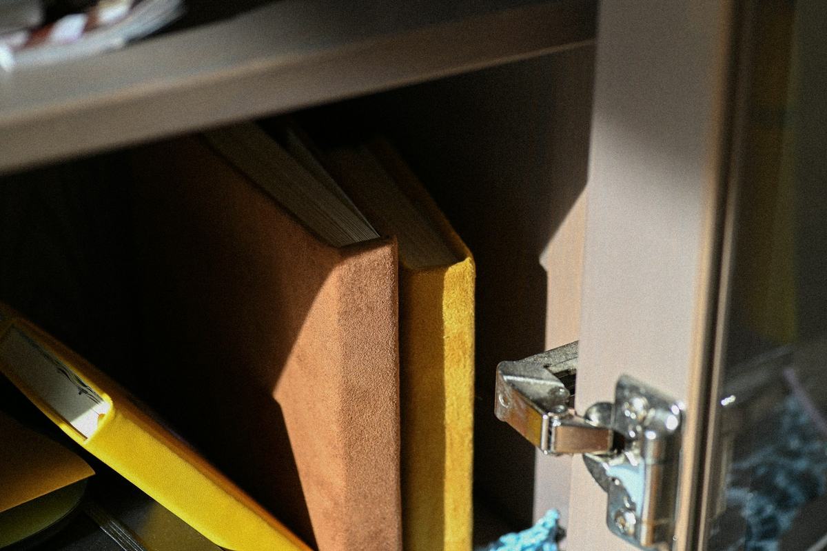 Close view of a concealed cabinet hinge on an open cabinet door.