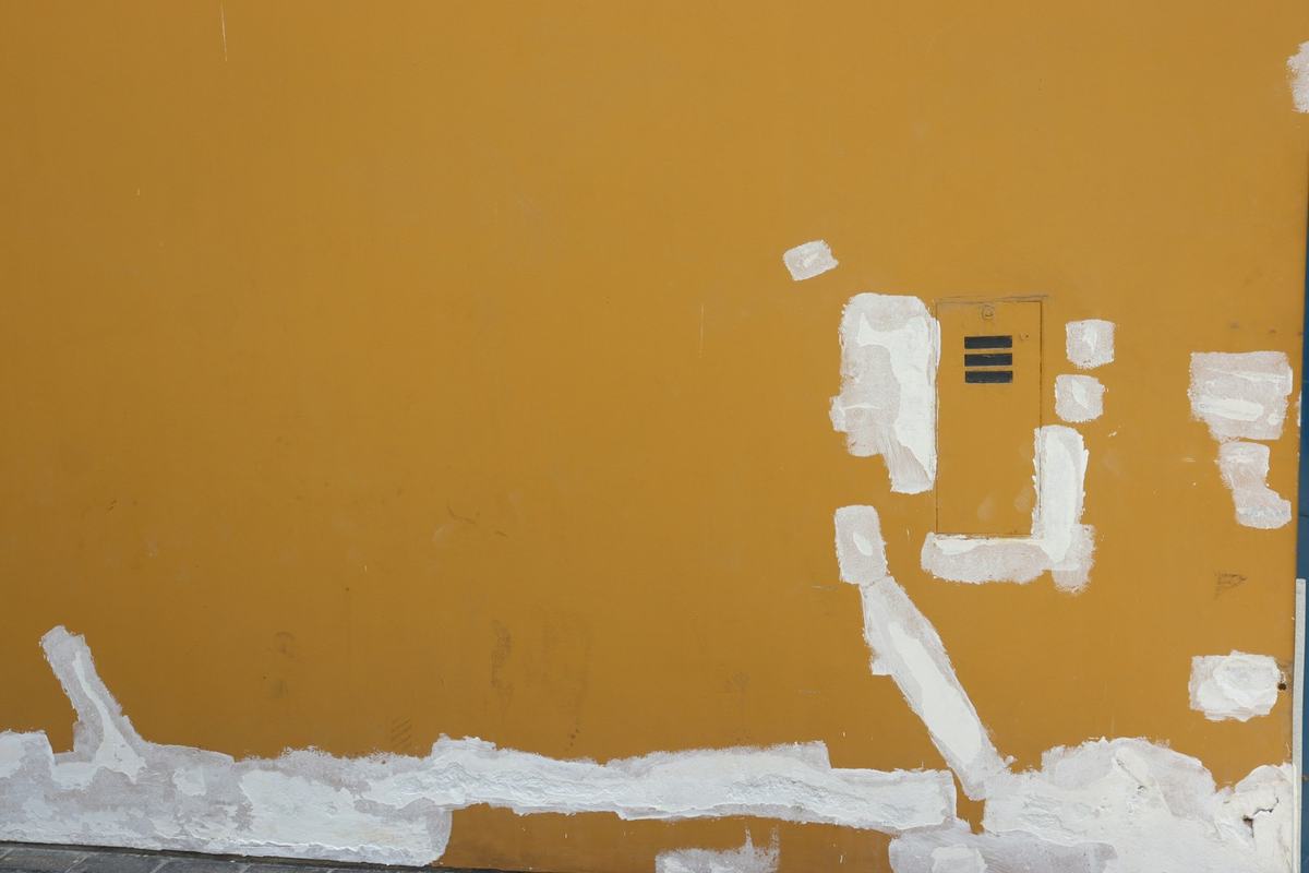 Wall with fresh patches of white compound around an opening before sanding and paint.