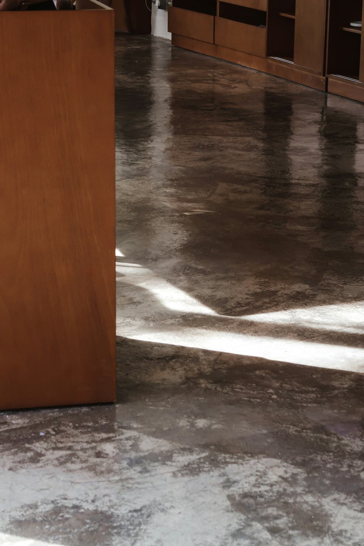 Glossy floor with a mottled, cloud-like pattern reflecting window light.