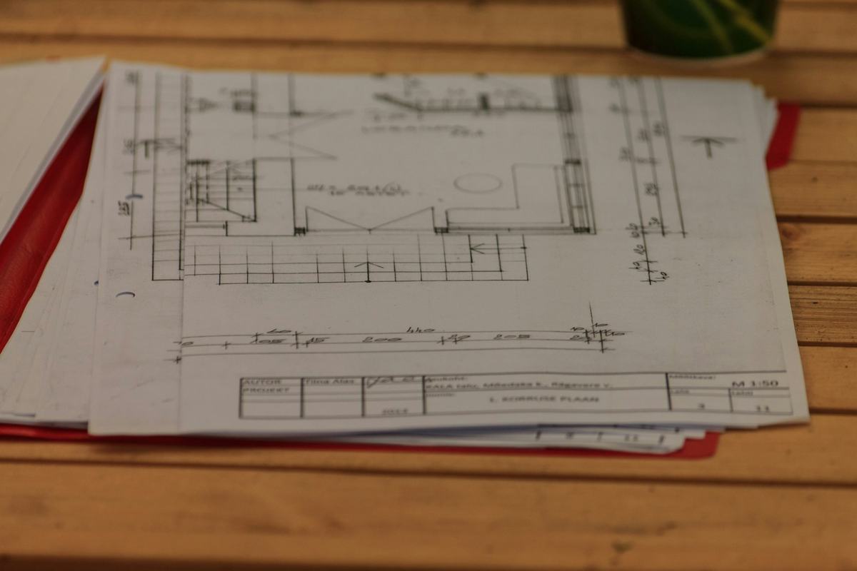 Printed floor plans laid on a wooden table.