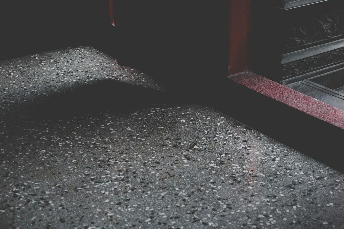 Close view of a dark surface with fine, densely packed light aggregate.