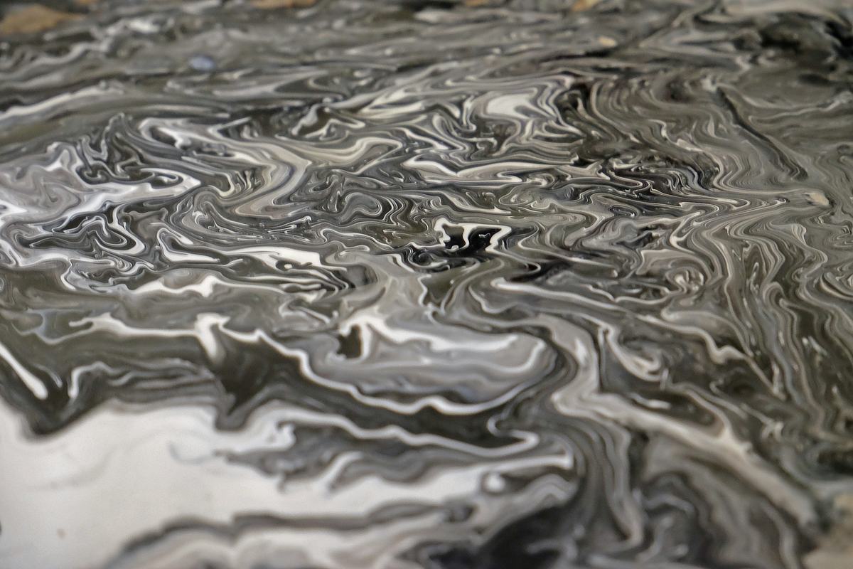 Close view of black, gray and white fluid marbled swirls.